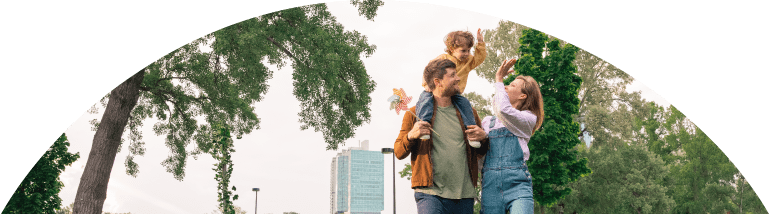 Eine Familie mit kleinem Kind machen High-Five in einem Park.